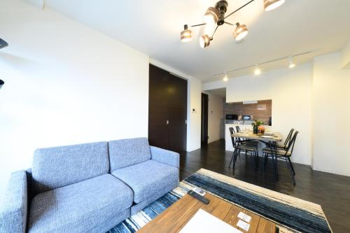 a living room with a couch and a table at GLASS Yamahana EAST in Minami-jūichijō