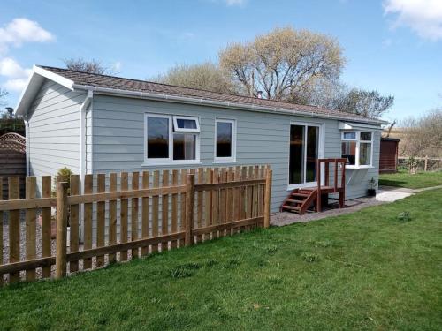 a small house with a fence in a yard at Family friendly rural lodge in Truro