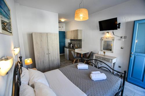a room with a bed and a table and a kitchen at KAMARADO STUDIOS in Kamarai
