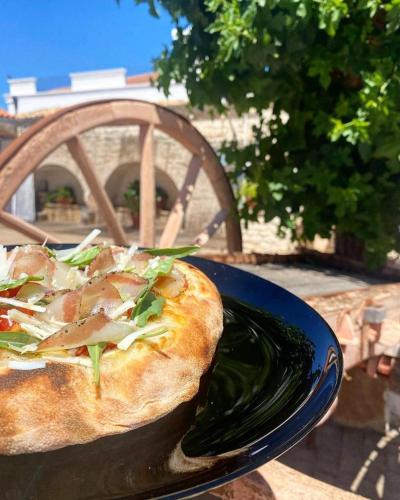 a pizza sitting on a blue plate on a table at B&B Villa Flora in Santeramo in Colle