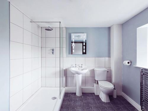 a bathroom with a sink and a toilet and a shower at Stable End Cottage in Bouth