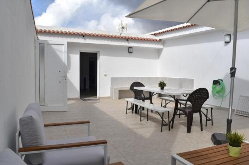 a patio with a table and chairs and an umbrella at Casa Sabare in Guinea