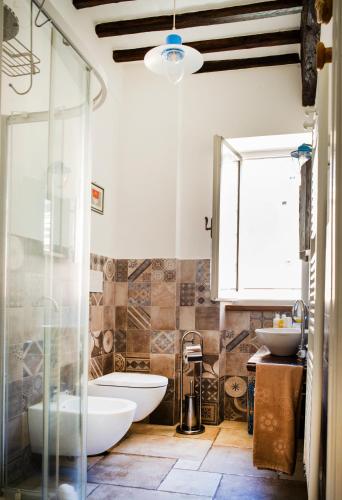 a bathroom with two sinks and a glass shower at ManillaHouse in Montepulciano