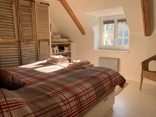 een slaapkamer met een bed en een raam bij La Petite Cour in Pont-Aven