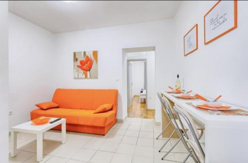 a living room with an orange couch and a table at Marija Apartments in Pula