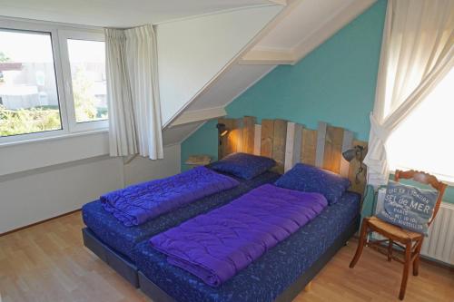 a large purple bed in a room with a window at Vakantiehuis Grevelingen 12 aan Grevelingenmeer. nabij Port Greve in Brouwershaven