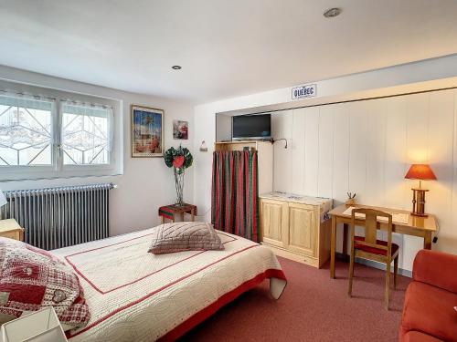 Schlafzimmer mit einem Bett, einem Schreibtisch und einem Tisch in der Unterkunft Neptune in Royan