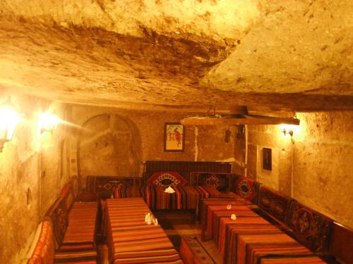 a room with rows of benches in a cave at Kapadokya Ihlara Konakları Otel Konak Odaları in Guzelyurt