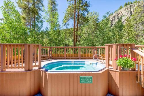 a hot tub on a patio with a wooden fence at 8782 Trappers Crossing Condo in Keystone