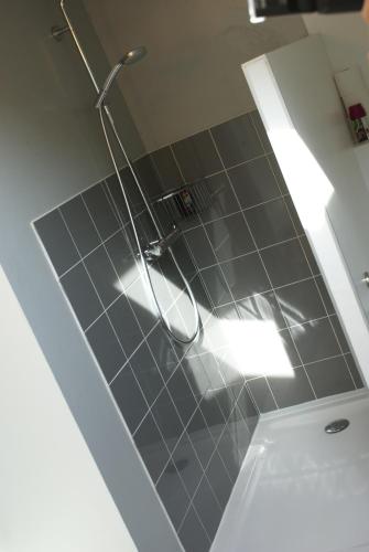 a bathroom with a shower and a tile floor at Chambre d'Hôtes Etchebri in Anglet