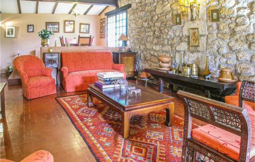 Elle comprend un salon doté d'un mobilier rouge et d'un mur en pierre. dans l'établissement Stunning Home In Cézac, à Marcamps