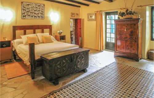 a bedroom with a large bed and a wooden dresser at Amazing Home In Czac With Outdoor Swimming Pool in Marcamps