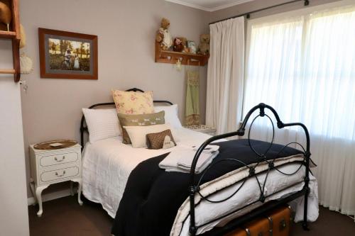 ein kleines Schlafzimmer mit einem Bett und einem Fenster in der Unterkunft Dragonflycottagebnb in Grovetown