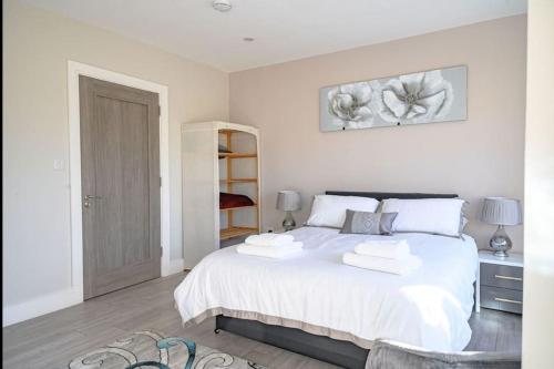 a bedroom with a white bed with two towels on it at No 1 Kinvara House in Killarney