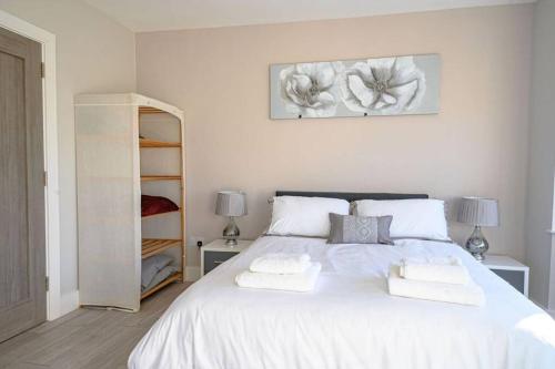 a bedroom with a white bed with two towels on it at No 1 Kinvara House in Killarney
