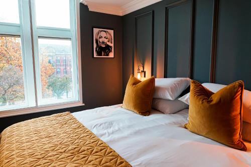 a bedroom with a large bed with two windows at The Old Post Office Warrington by Deuce Hotels in Warrington