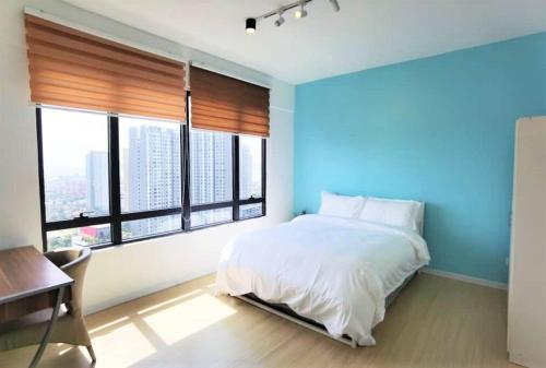 a bedroom with a white bed and a blue wall at Lovers under Cupid's Arrow 丘比特之箭下の恋人 in Butterworth