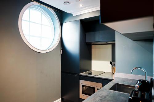 a kitchen with a round window above a sink at The Old Post Office Warrington by Deuce Hotels in Warrington