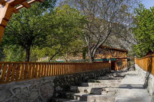 a wooden fence and stairs in front of trees at Walnut Heights By Roomy, Kalam in Kalām