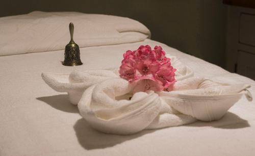 a pink flower in a bowl on a bed at Black Sheep Hotels Cabins in Spean Bridge