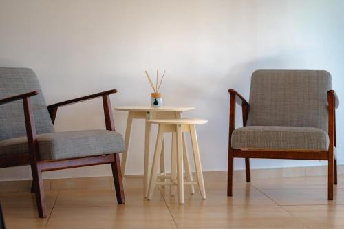 two chairs and a small table with a table between two chairs at Villa à l'entrée de Porticcio - Piscine - Vue dégagée in Cauro
