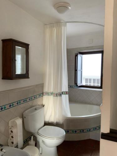 uma casa de banho com uma banheira, um WC e um lavatório. em Bonita casa rústica sierra de Cádiz em Benaocaz