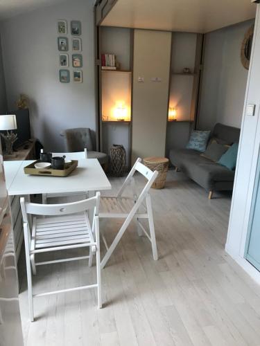 a living room with a table and chairs and a couch at Studio Le Sandettie à 50m de la plage! in Fort-Mahon-Plage