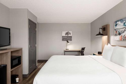 a hotel room with a bed and a television at La Quinta Inn by Wyndham Temple in Temple