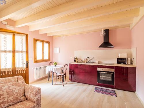 una cocina con armarios rojos y una mesa en una habitación en Casa Rural Picu Llagos, en Cangas de Onís