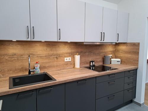 a kitchen with white cabinets and a sink at Ferienwohnung zum Peterbauer in Sachsenkam
