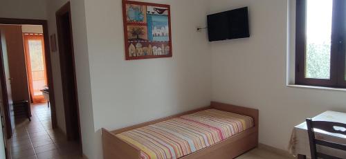 a bed in a room with a tv on the wall at Casa Vacanze la Paloma in Peschici