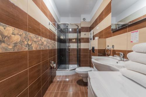a bathroom with a shower and a toilet and a sink at Apartamenty NCNK Mierzeja Park Sztutowo in Sztutowo