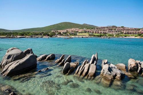 a group of rocks in the water near a beach at Residence Baia de Bahas Golfo di Marinella in Santa Marinella