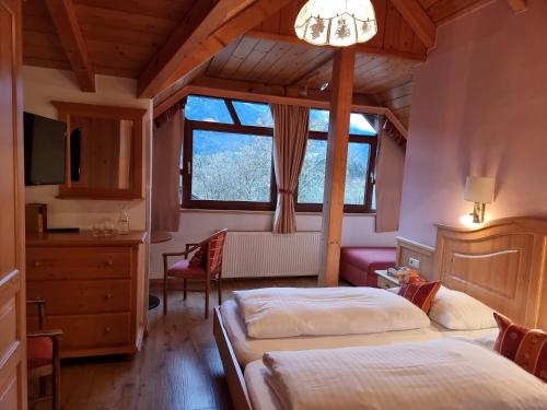 1 Schlafzimmer mit 2 Betten und einem Fenster in der Unterkunft Karnischer Hof in Sankt Stefan an der Gail