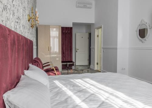 a bedroom with a large bed with a red headboard at Hotel Vila Central Boutique Satu Mare in Satu Mare