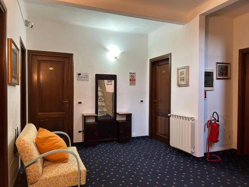 a living room with a chair and a mirror at Hotel Marnie in Massarosa