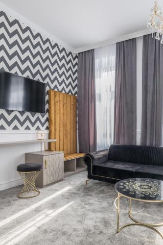 a living room with a black couch and a table at Hotel Vila Central Boutique Satu Mare in Satu Mare