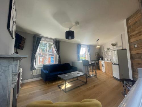 ein Wohnzimmer mit einem blauen Sofa und einem Tisch in der Unterkunft Brady’s Glastonbury beautiful pad great location! in Glastonbury