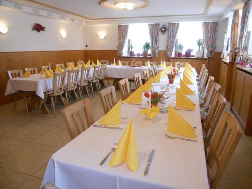 比格蘭的住宿－Landgasthof Zum Schloss，一间设有白色桌子和黄色餐巾的用餐室