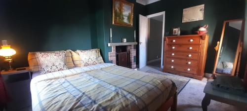 a bedroom with a bed and a dresser at Stable cottage cozy,quirky with a hot tub in Bridlington