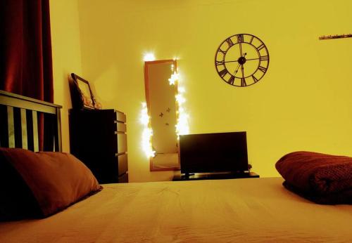 a bedroom with a bed and a clock on the wall at Full Apartment in Central Al Ain (All Amenities) in Al Ain