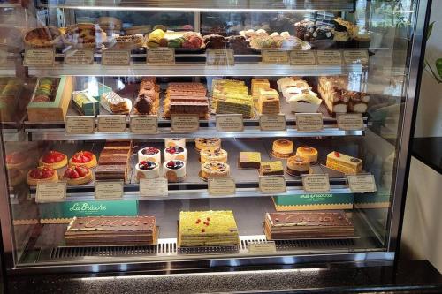 a display case filled with different types of cakes and pastries at Full Apartment in Central Al Ain (All Amenities) in Al Ain