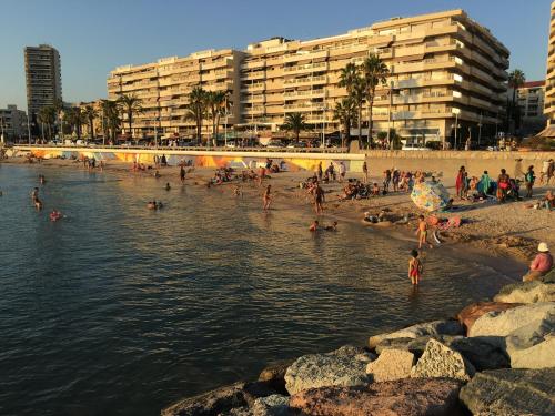 a group of people on a beach near the water at TRIANGLE D OR 55m2 en bord de plage in Saint-Raphaël