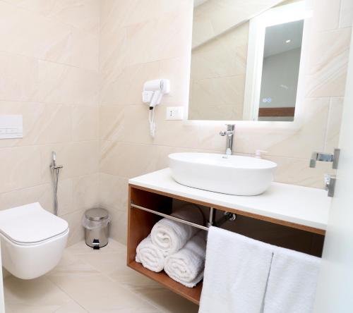 a bathroom with a sink and a toilet at Vila ELARAD in Vlorë