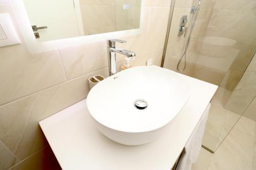 a bathroom with a white sink and a shower at Vila ELARAD in Vlorë