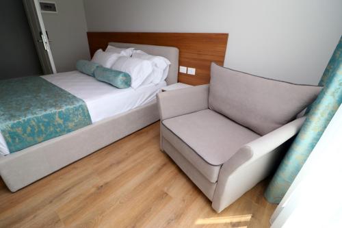 a bedroom with a bed and a couch and a chair at Vila ELARAD in Vlorë