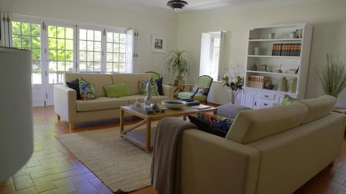 a living room with two couches and a table at Vila Louro in Santa Cruz