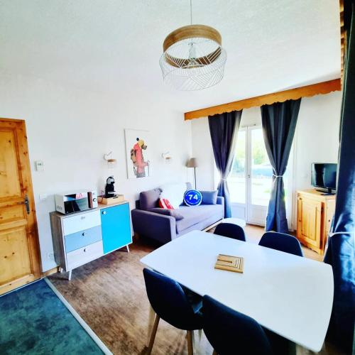 un salon avec une table et des chaises dans l'établissement Appartement avec piscine & jardin pied de la télécabine, à Saint-Gervais-les-Bains