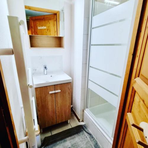 une salle de bain avec un lavabo et une douche dans l'établissement Appartement avec piscine & jardin pied de la télécabine, à Saint-Gervais-les-Bains