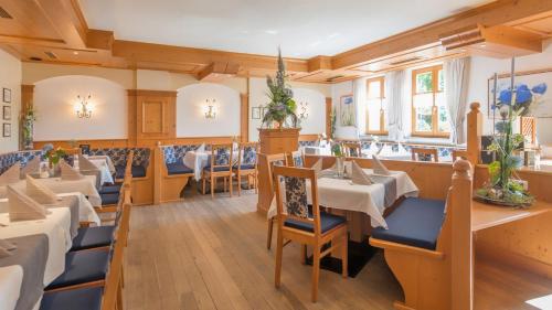 ein Restaurant mit Tischen und Stühlen in einem Zimmer in der Unterkunft Zum Kirchenwirt in Neukirchen vorm Wald